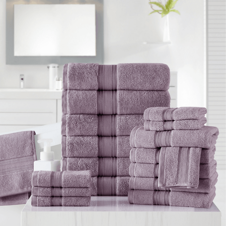 Stack of purple towels on a white surface with a bathroom setting in the background