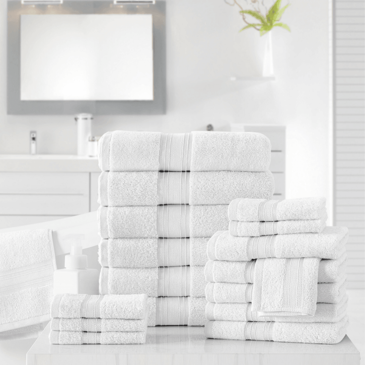 Stacks of white towels on a bathroom counter with a mirror in the background.