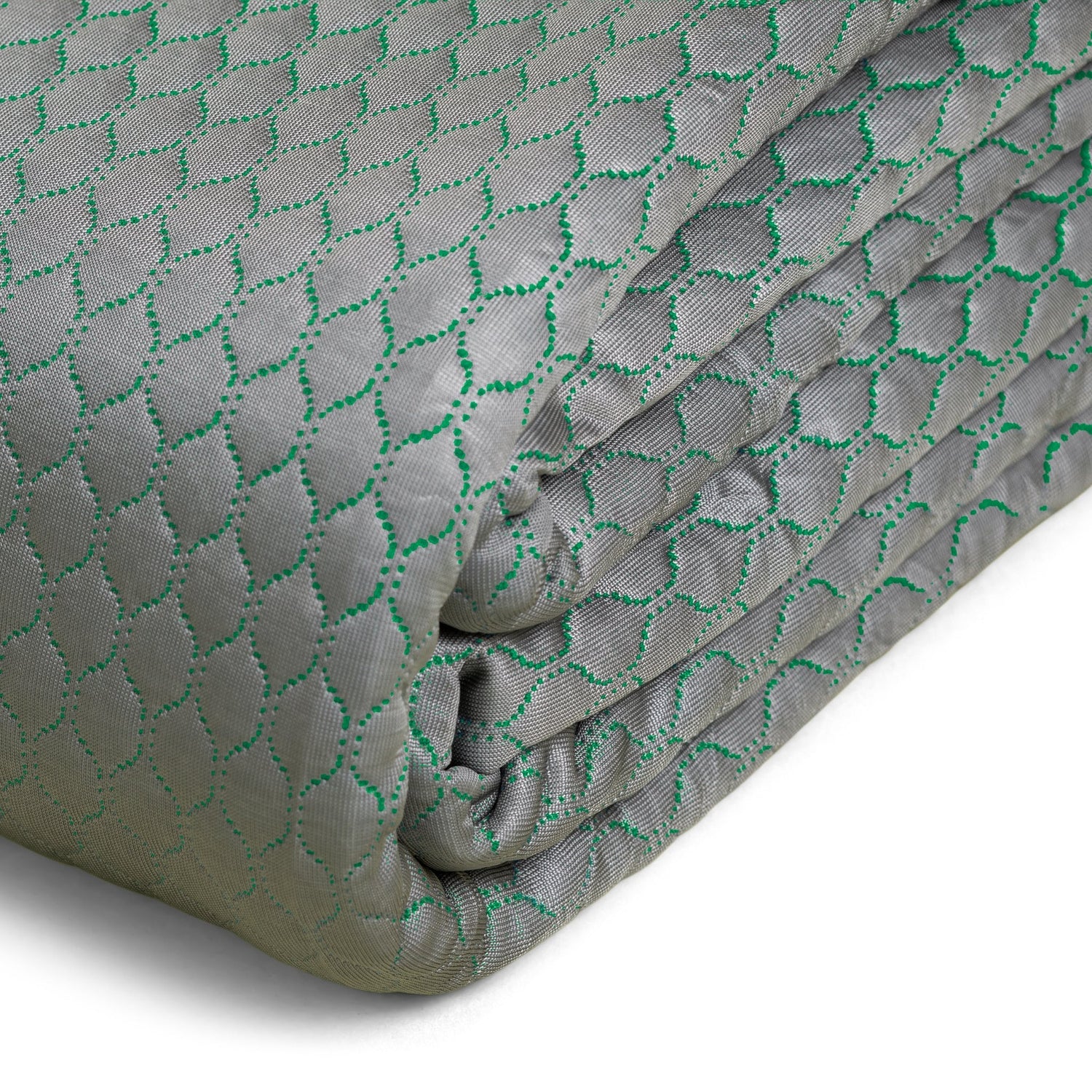 Folded fabric with a green geometric pattern on a gray background
