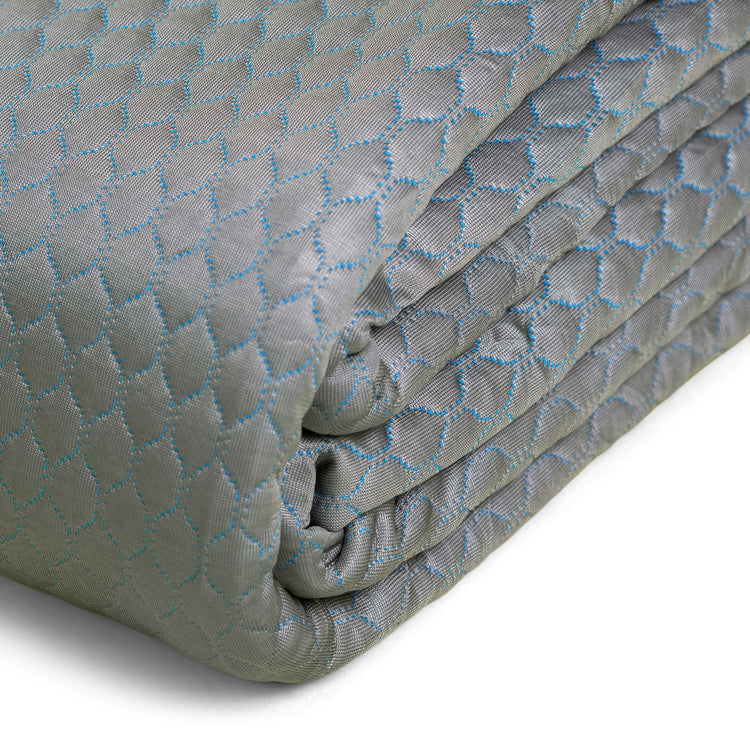 Folded quilt with geometric pattern on a white background