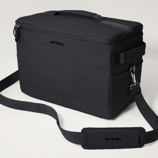 Black cooler bag with a shoulder strap on a light gray background