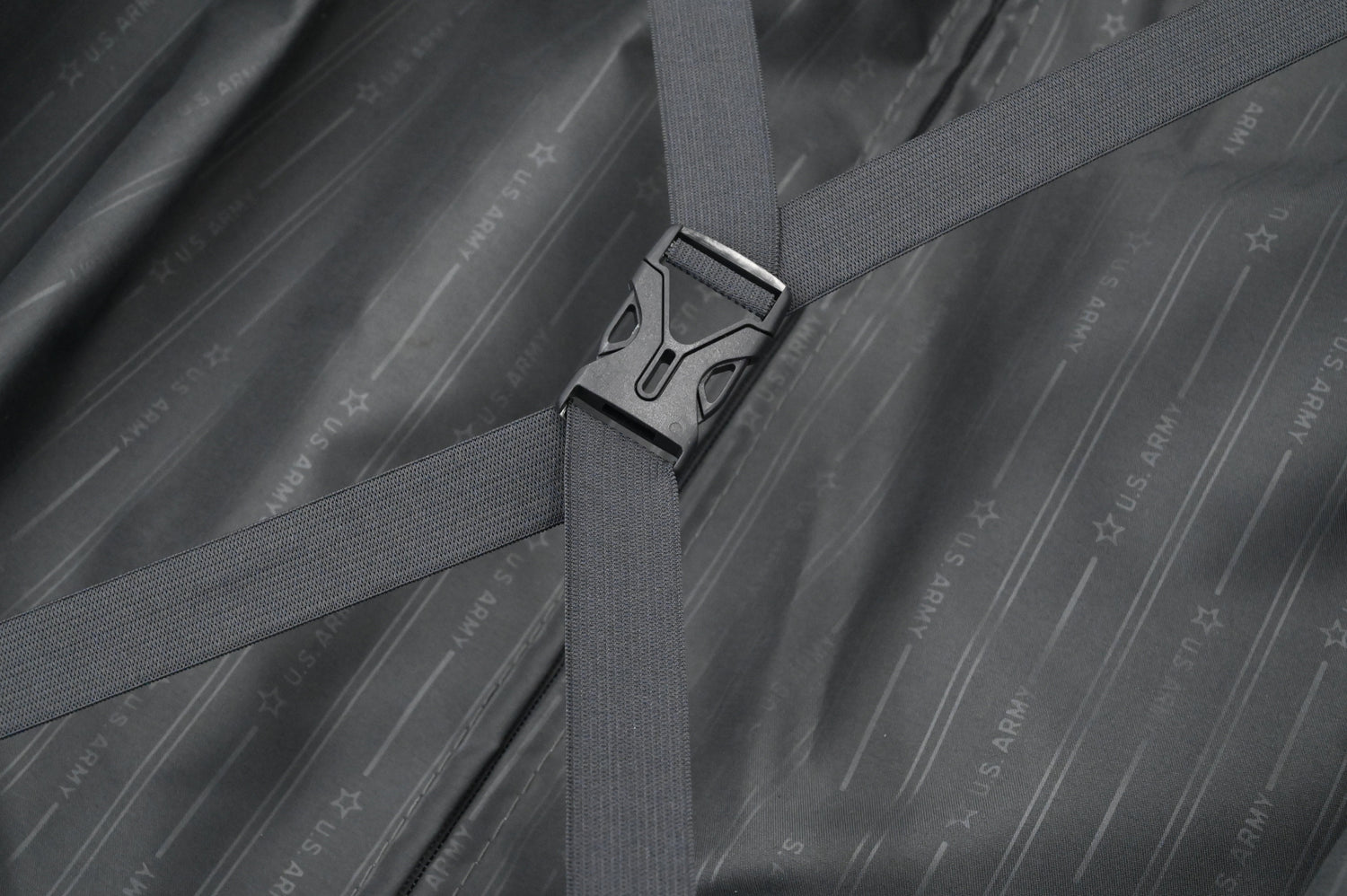 Close-up of a gray strap with a buckle on a textured gray background