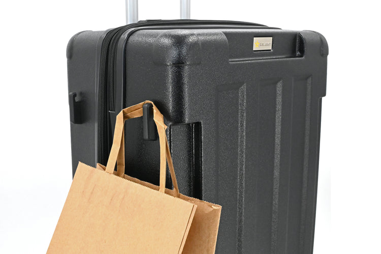 Black suitcase with a brown paper bag on a white background