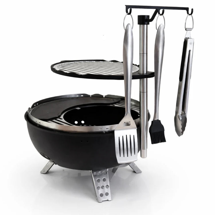 Black portable grill with cooking utensils on a white background