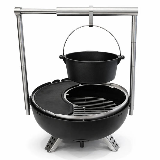 Grill with skewers of meat over an open flame on a wooden deck.