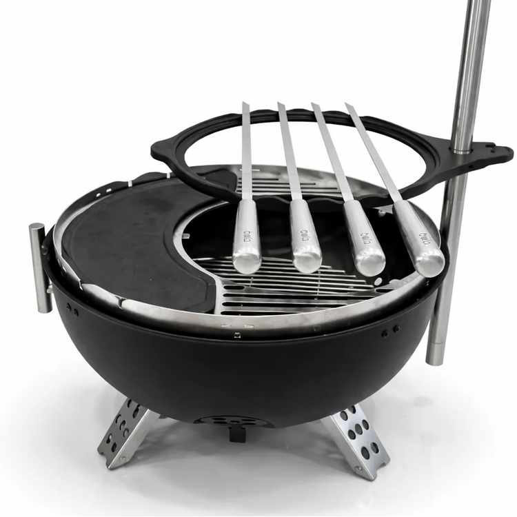 Black portable grill with metal skewers on a white background