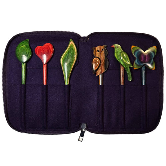 Set of colorful wooden spoons in a black case on a white background