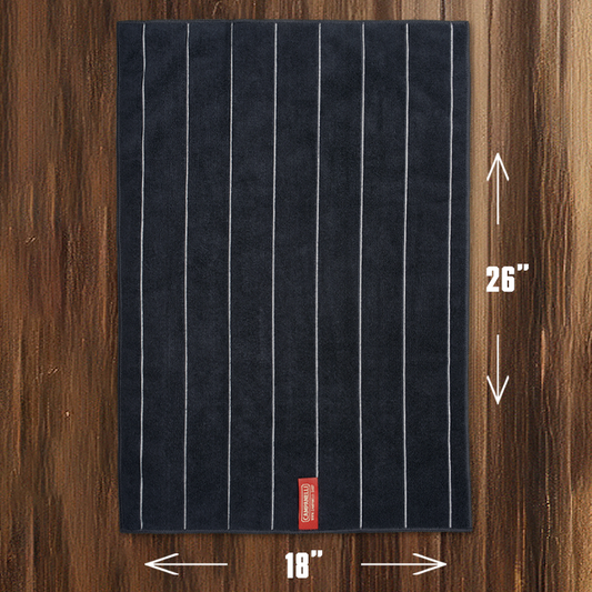 Stack of dark blue towels with white stripes and a red label on a white background