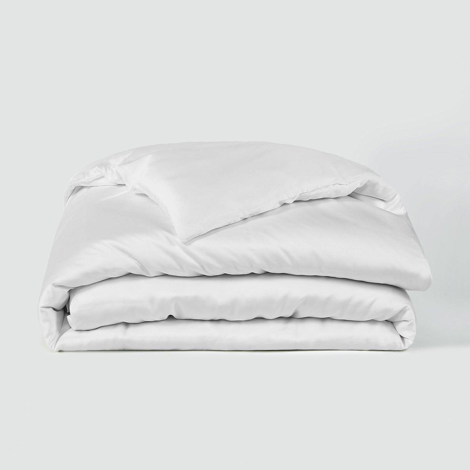 Stack of white bedding on a light gray background
