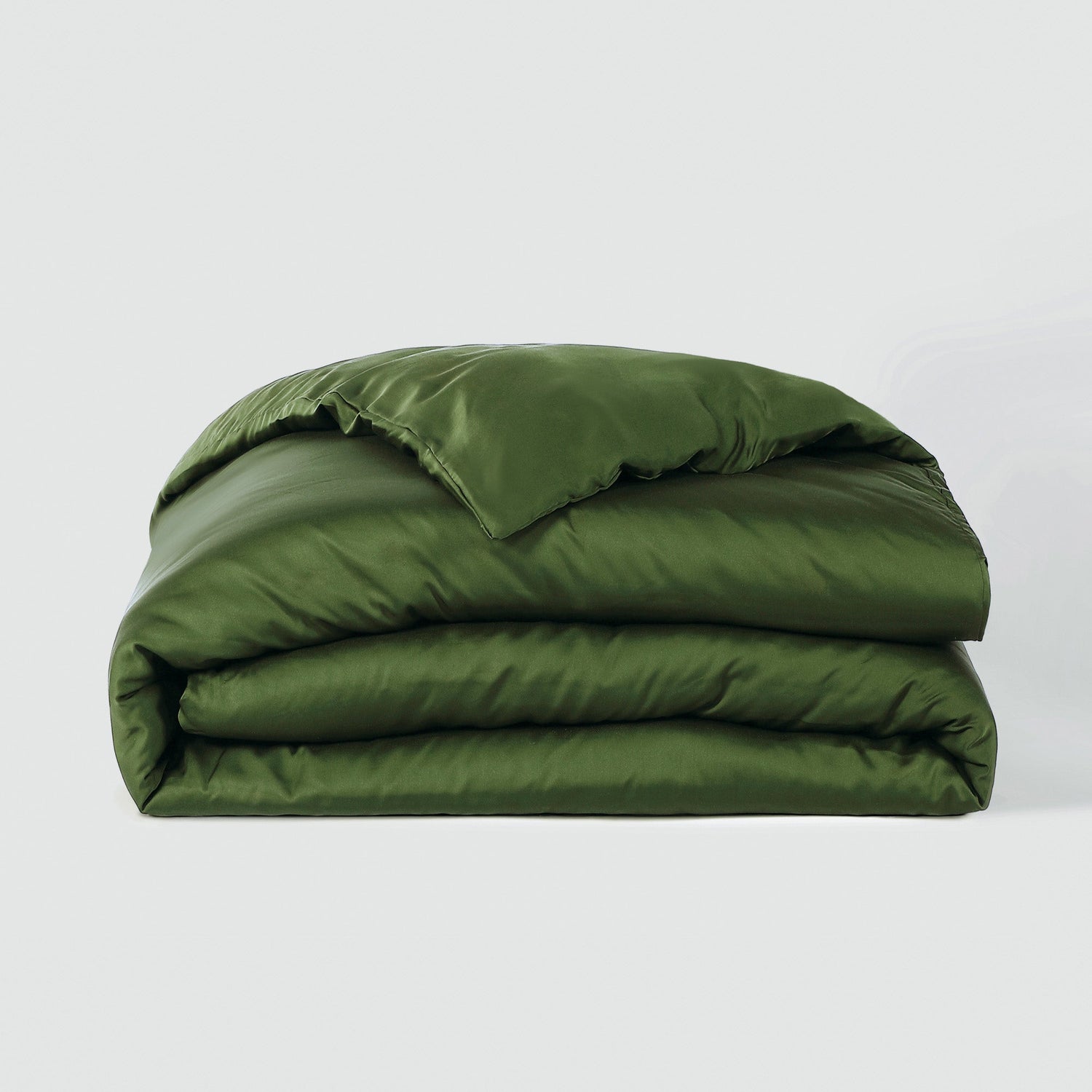 Green quilted comforter on a white background