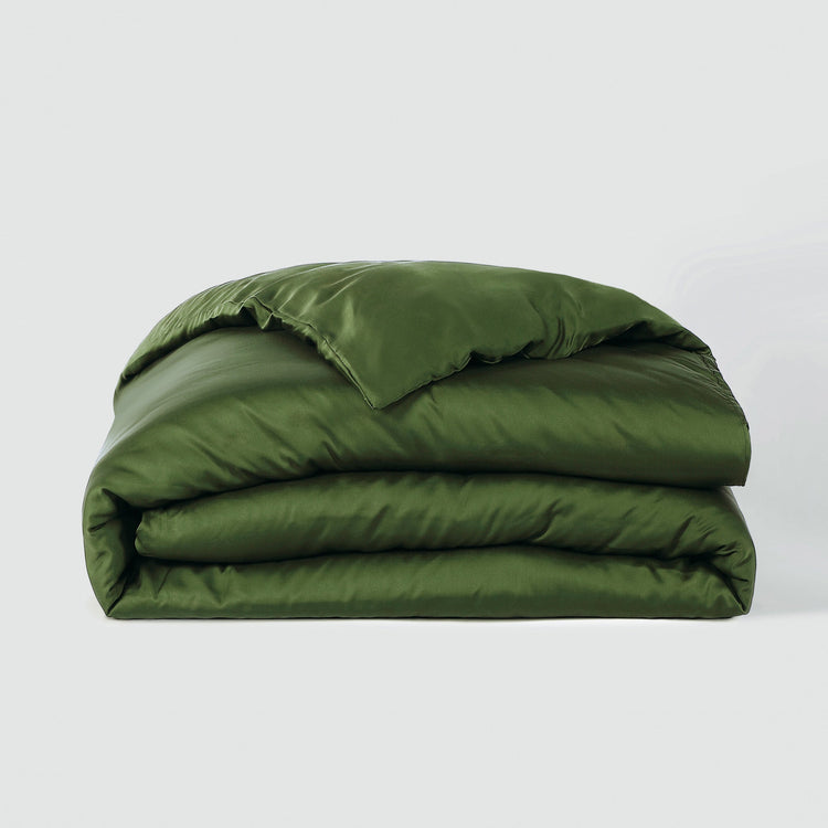 Green quilted comforter on a white background