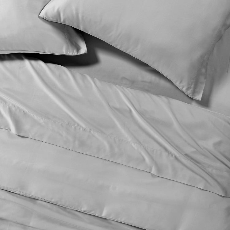 Gray bedding set with pillows on a plain background