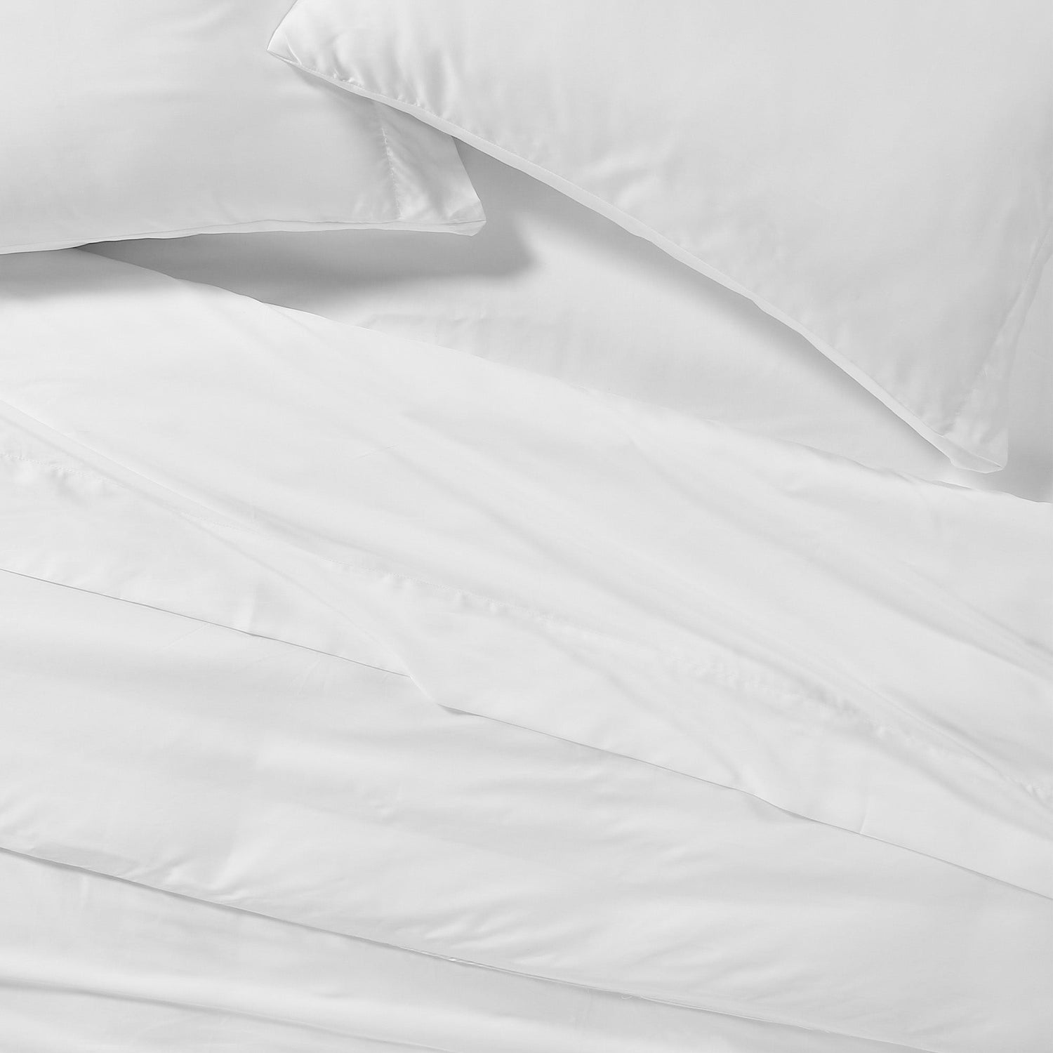 Close-up of white bedding with a pillow on a light gray background