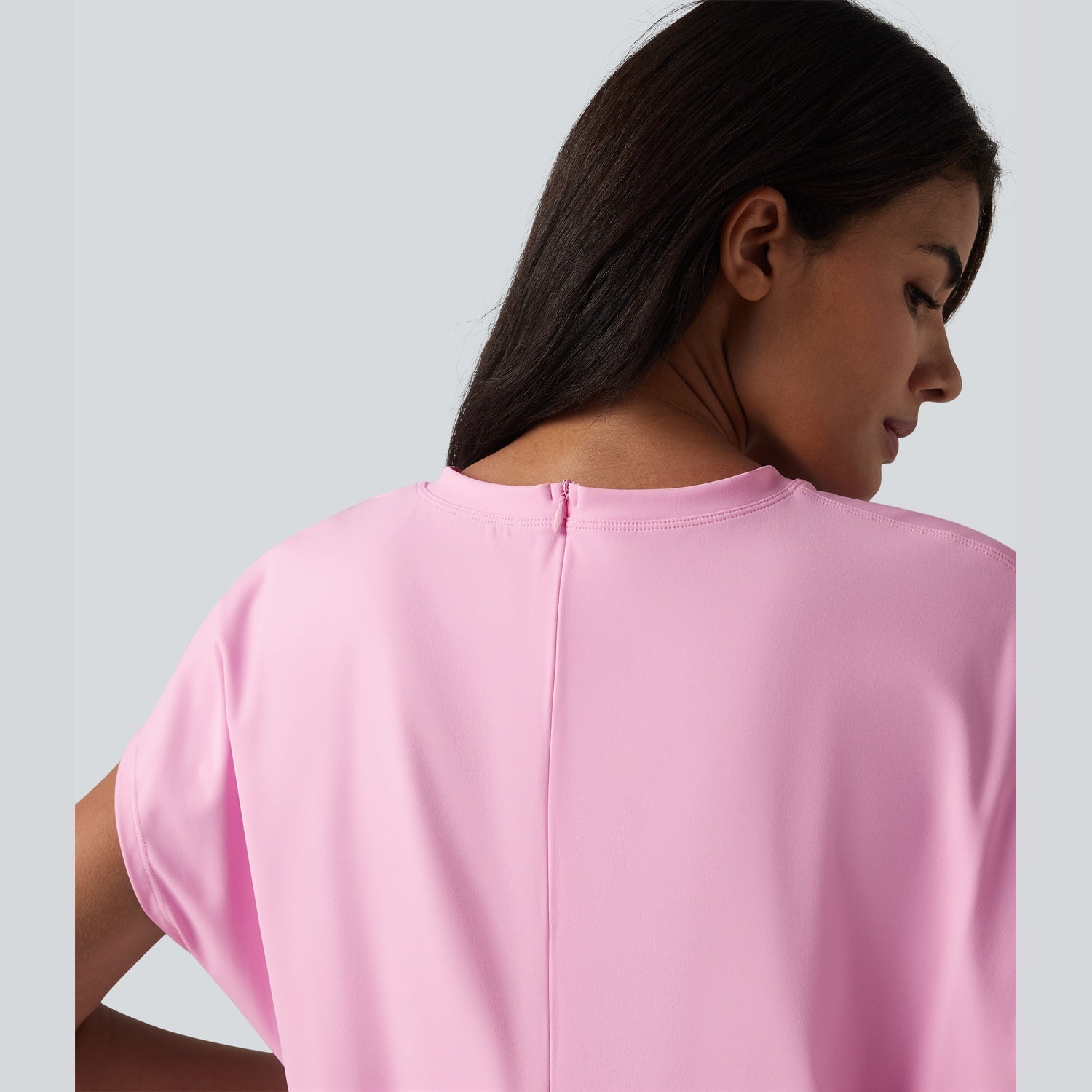 Woman wearing a pink dress against a light gray background