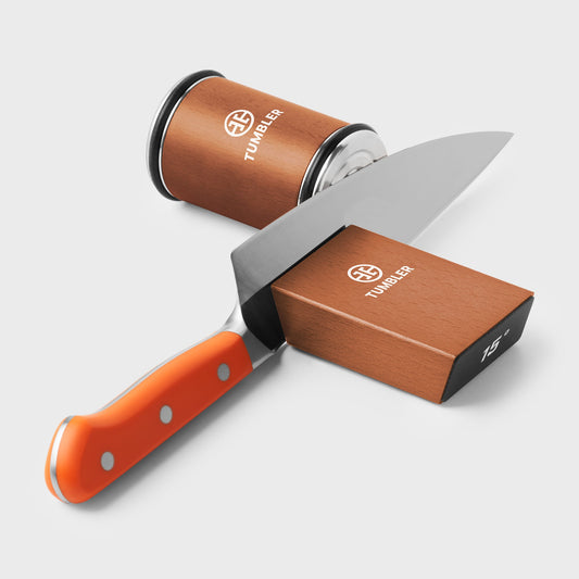 Orange Tumbler packaging box with branded items on a light gray background