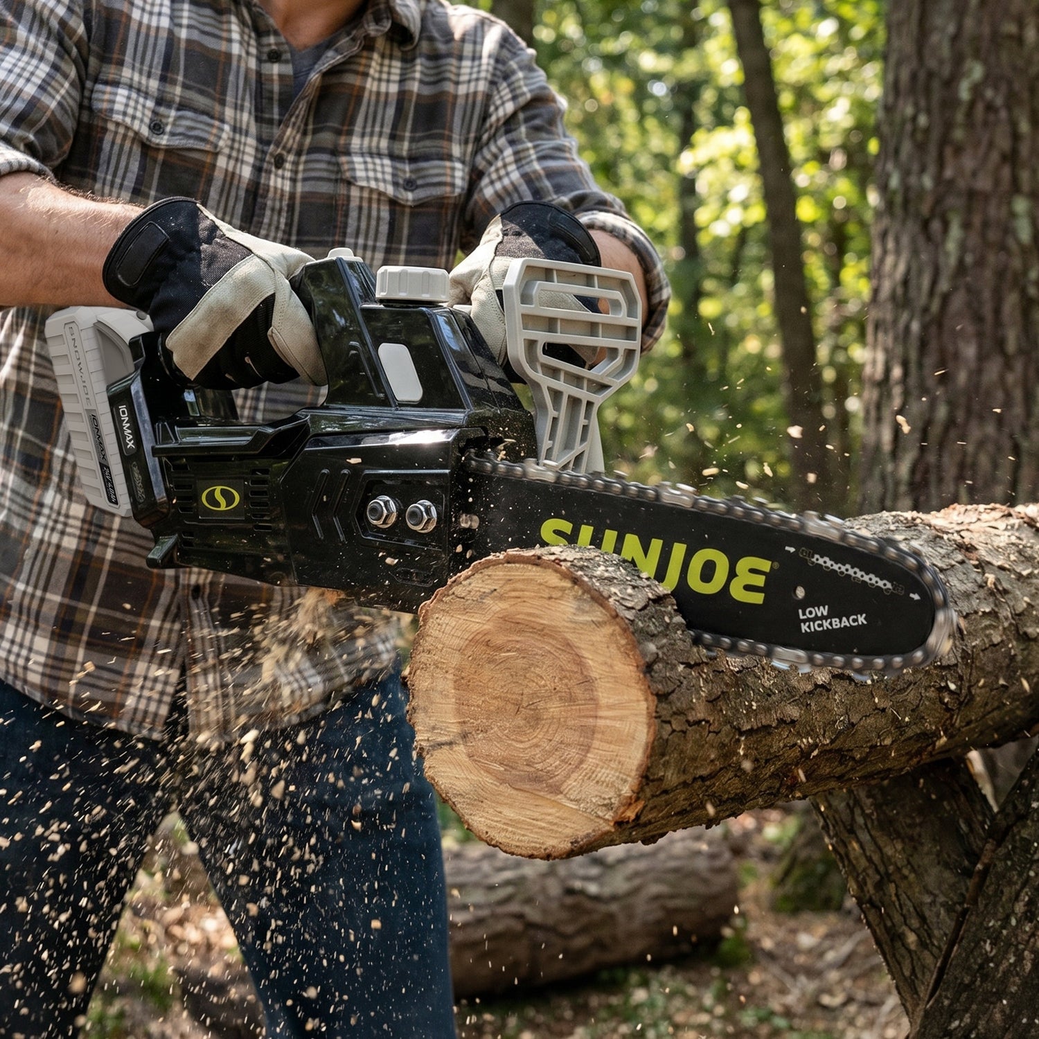 Person using a Sun Joe chainsaw to cut a log in a forest setting