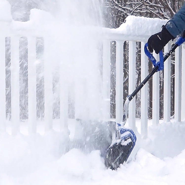 Person shoveling snow from a deck with a blue shovel