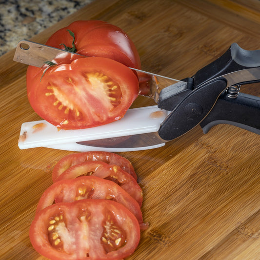 Set of kitchen tools including a peeler, mandoline, and other cutting tools with sliced vegetables on a white background.