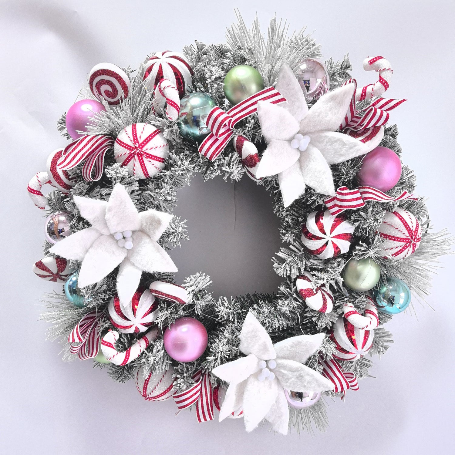 Decorative Christmas wreath with candy-themed ornaments on a white background