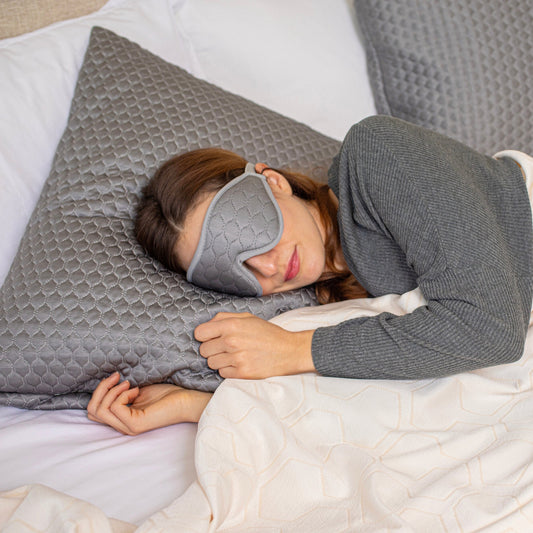 Gray quilted eye mask with a brand tag on a white background