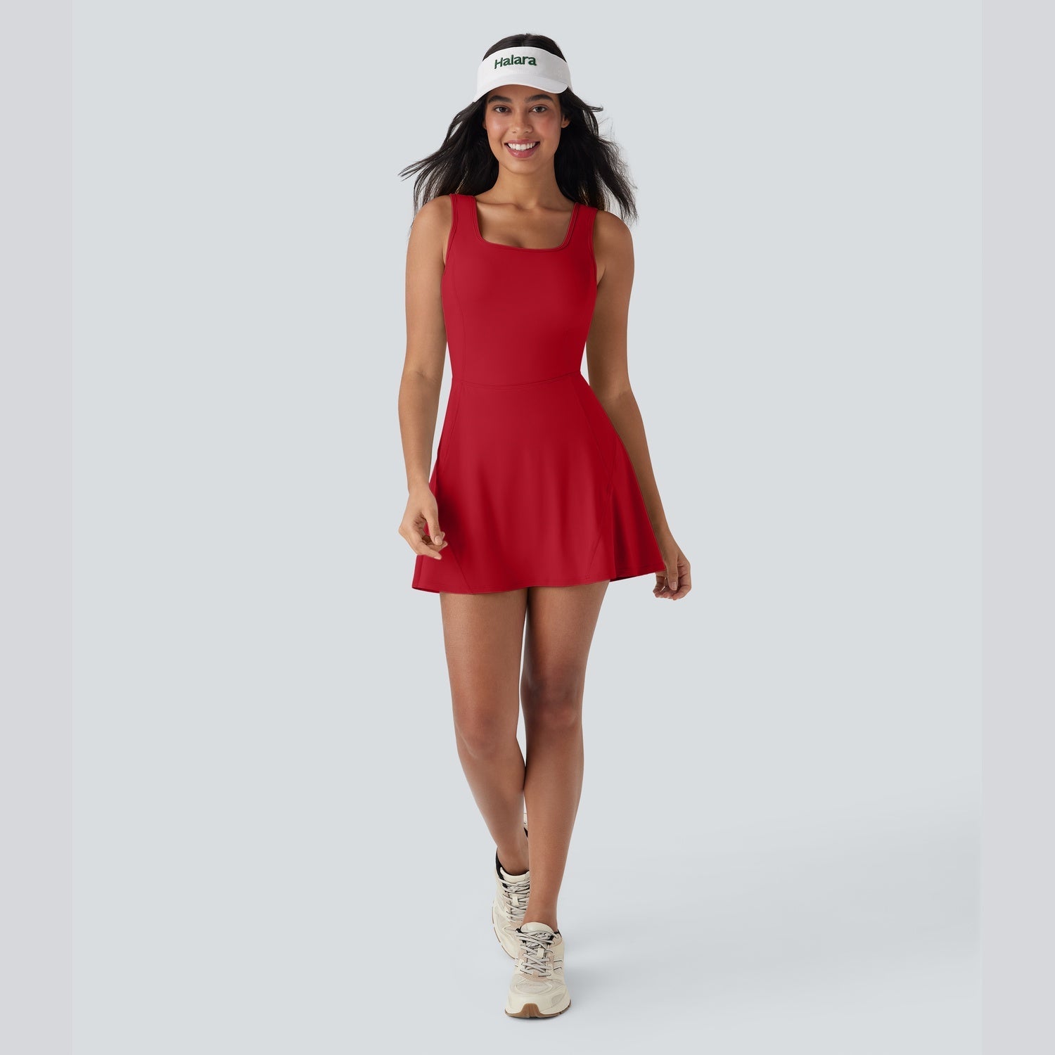 Woman wearing a red dress and visor on a white background