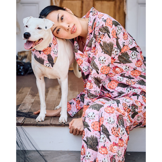 Woman wearing a pink floral onesie against a plain background
