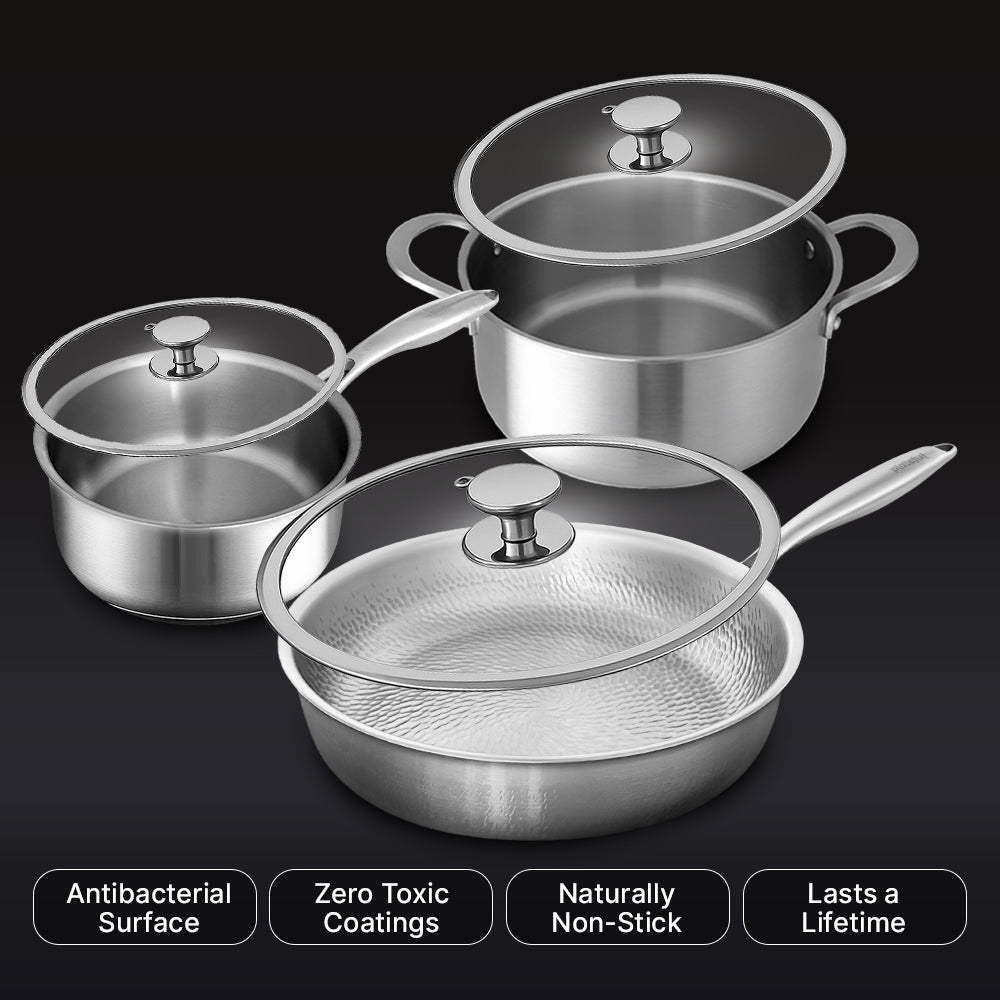 Set of stainless steel cookware with lids on a black background
