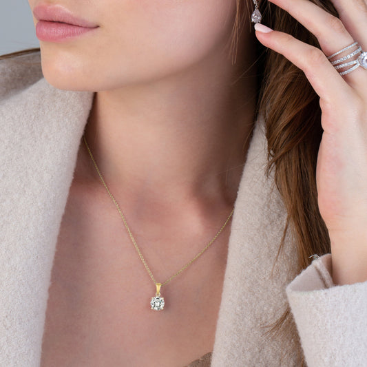 Gold necklace with a diamond pendant on a white background