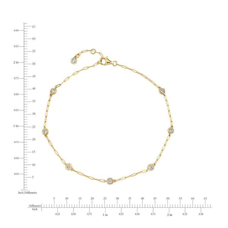 Gold bracelet with diamond accents on a white background with measurement scale