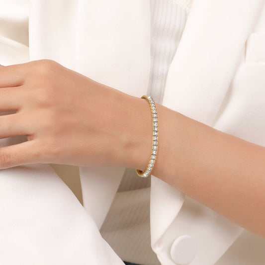 Gold bracelet with clear gemstones on a white background