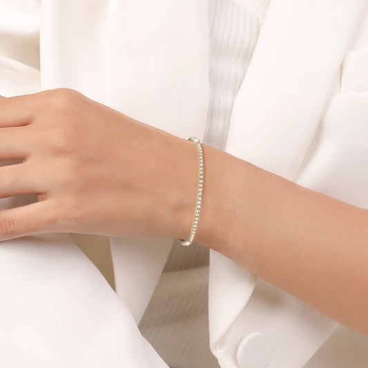 Gold bracelet with clear stones on a white background