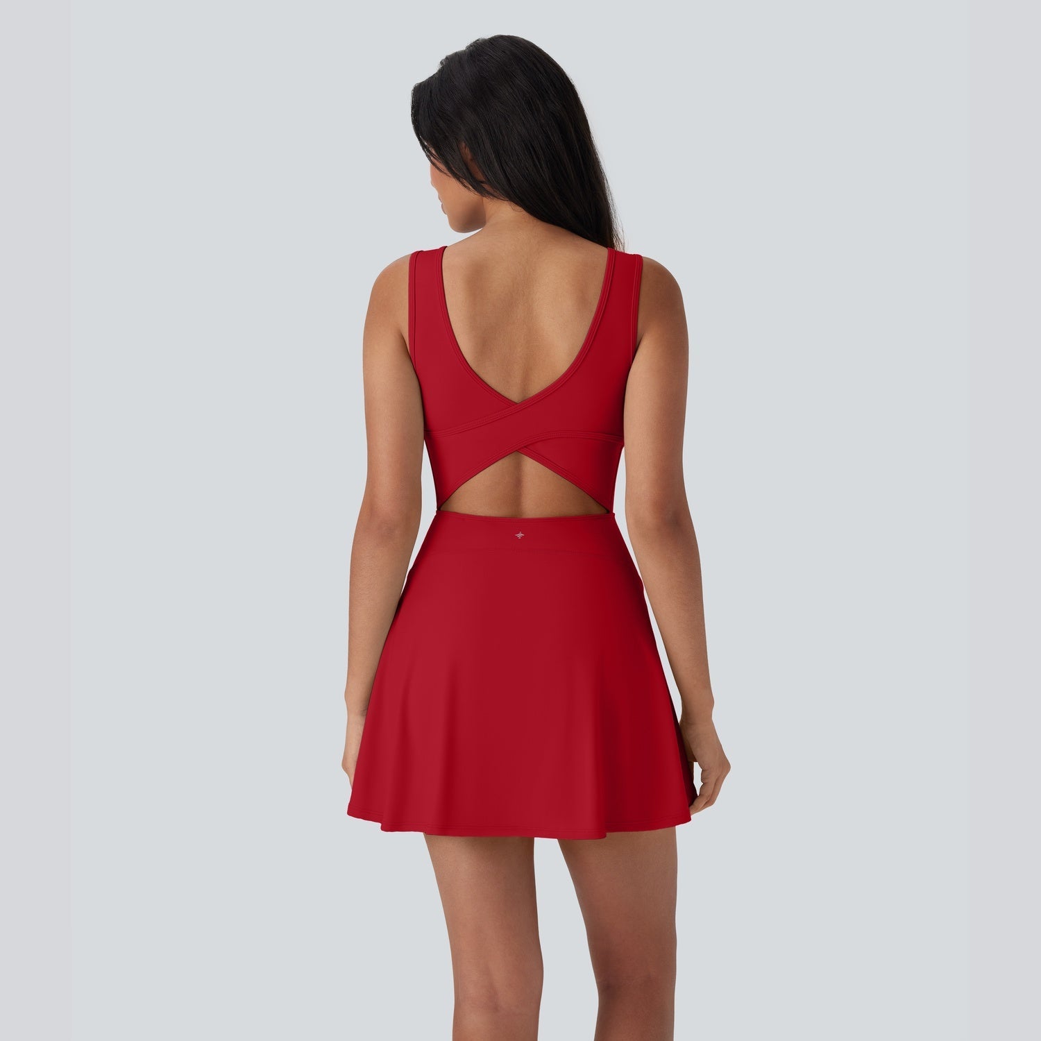 Red dress with cut-out back worn by a person on a light gray background