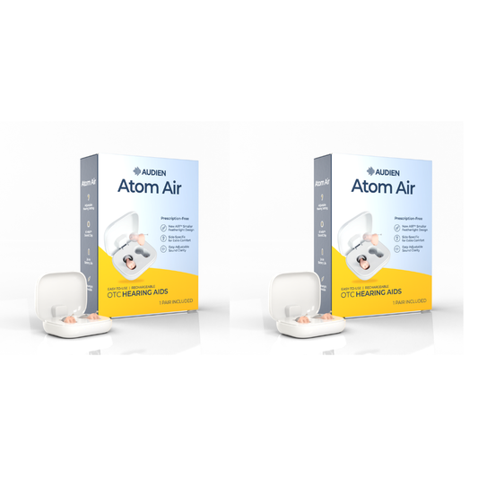 Two boxes of Audien Atom Air OTC Hearing Aids with their white charging cases and pink hearing inserts displayed in front, set against a clean white background.