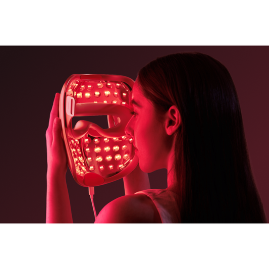 Beauty device with red light panel and metallic cover on a white background
