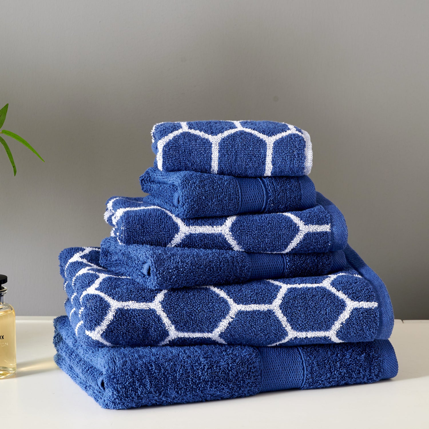 Set of blue towels with white geometric patterns on a neutral background
