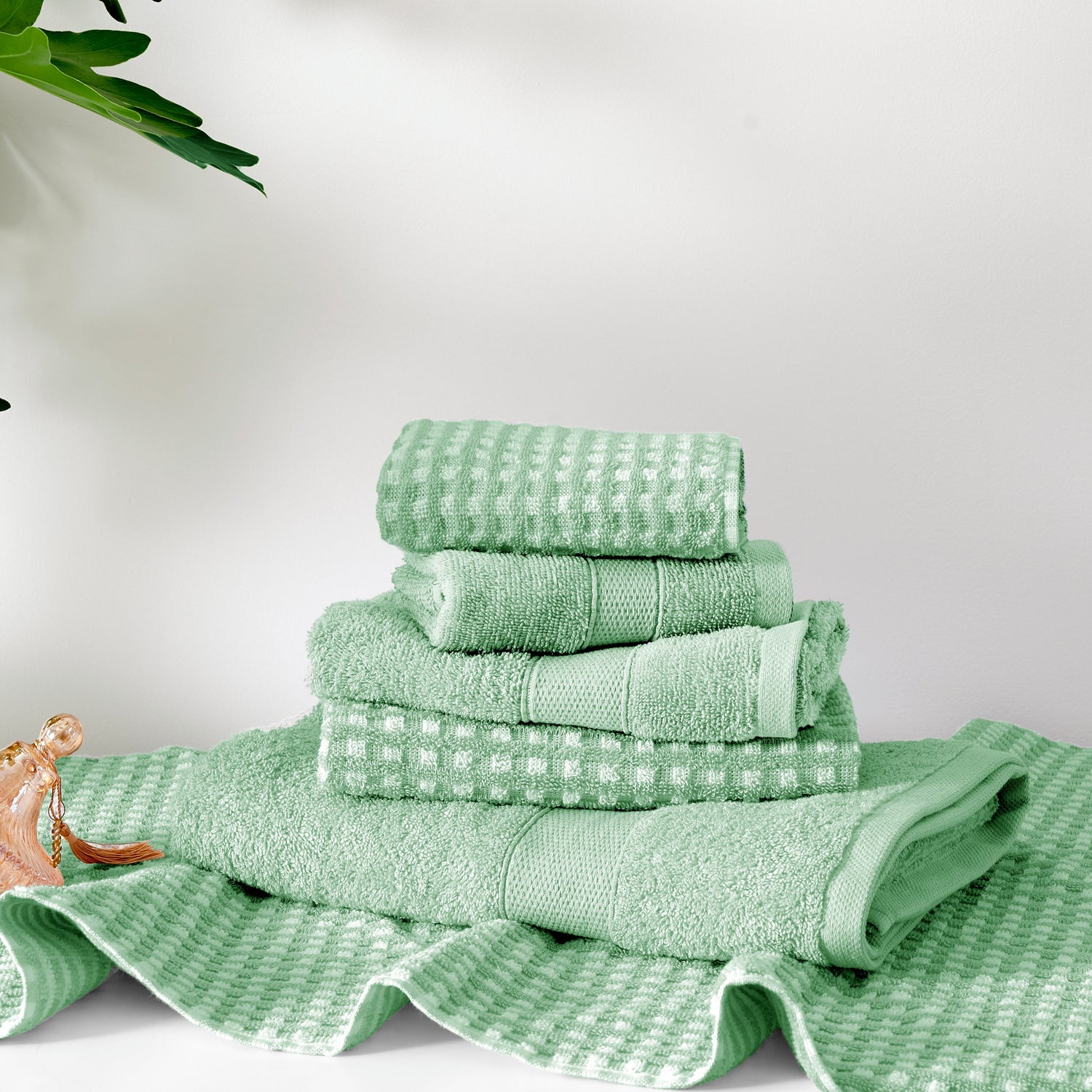 Stack of green towels on a white background