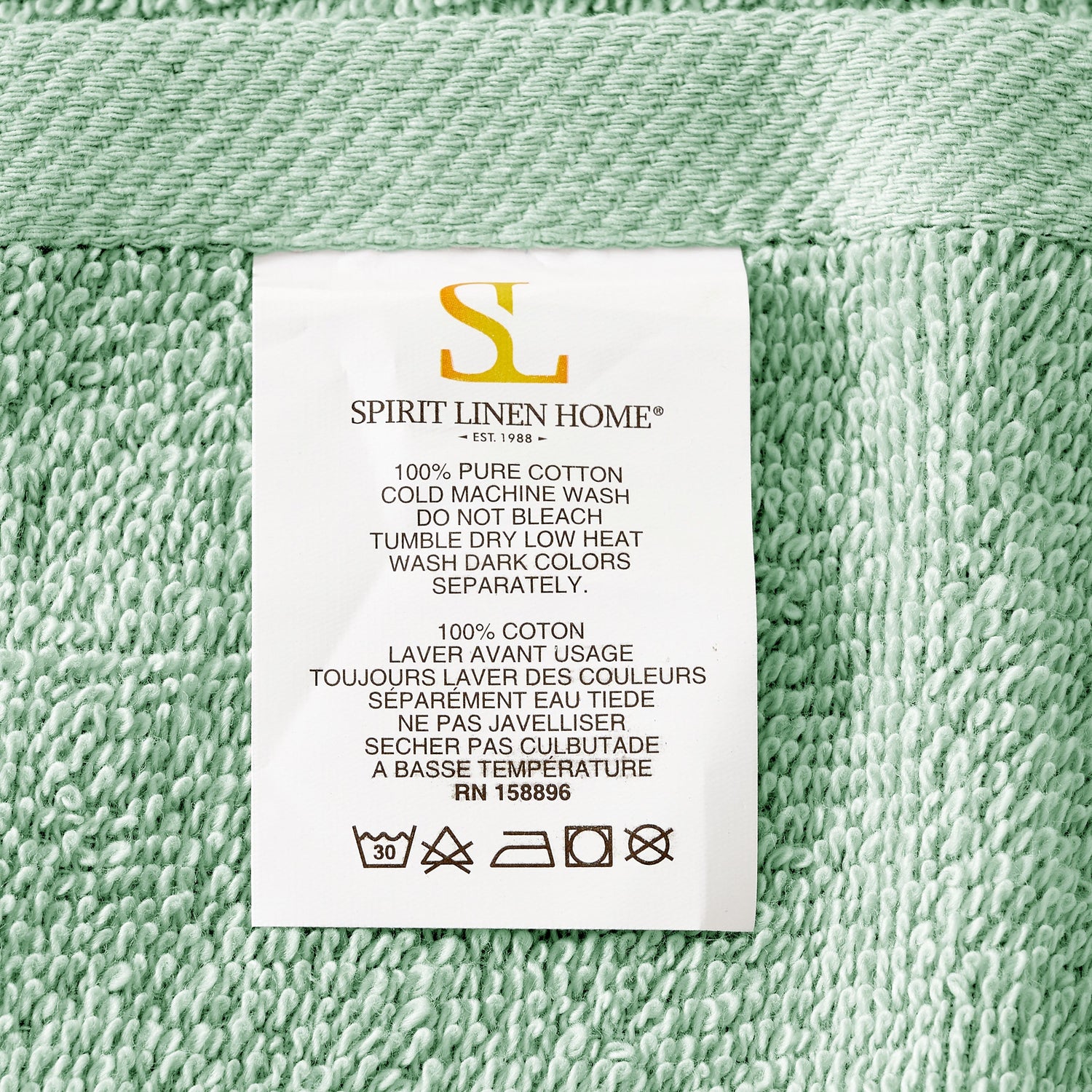 Label on green fabric with 'Spirit Linen Home' branding and washing instructions.
