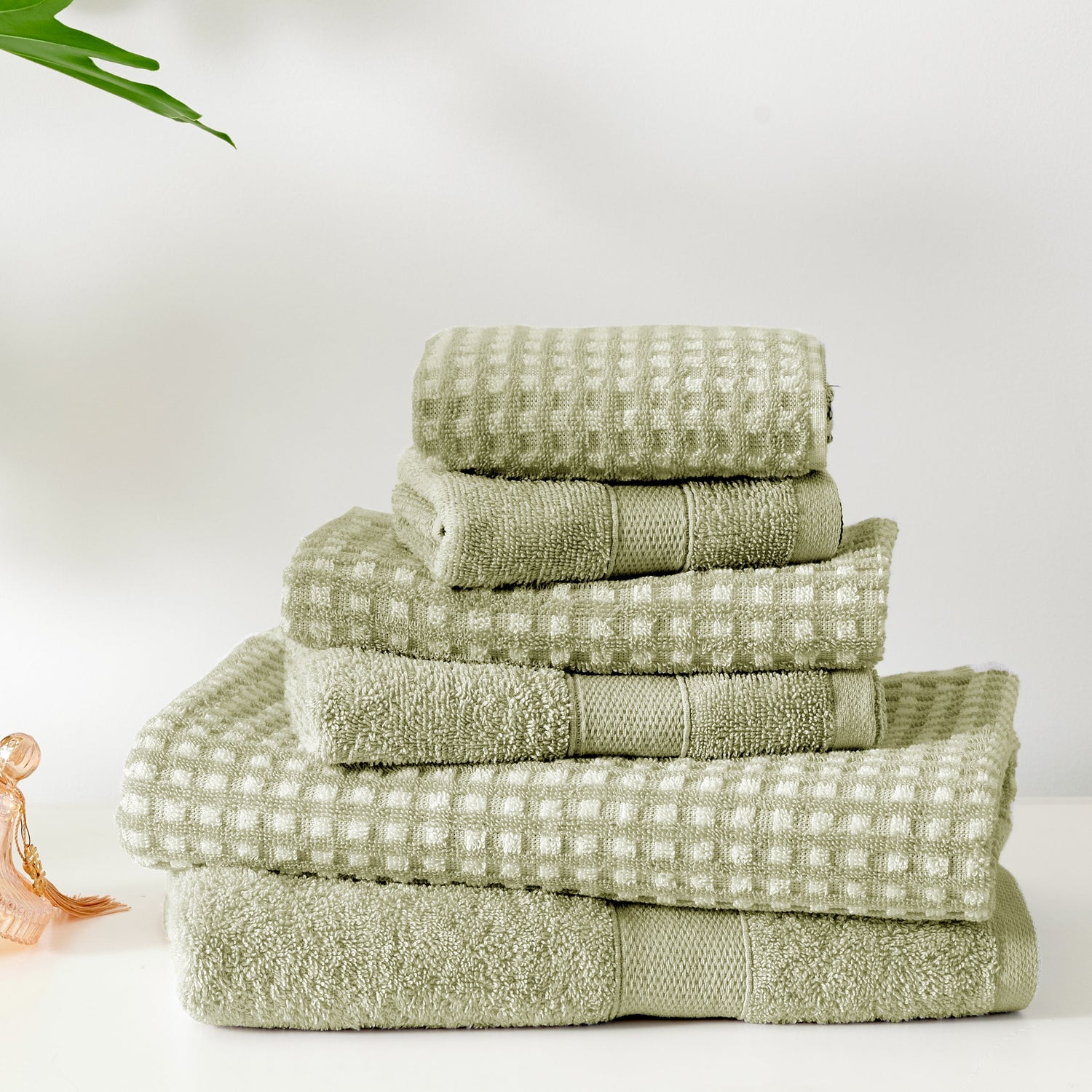 Stack of green towels on a white background
