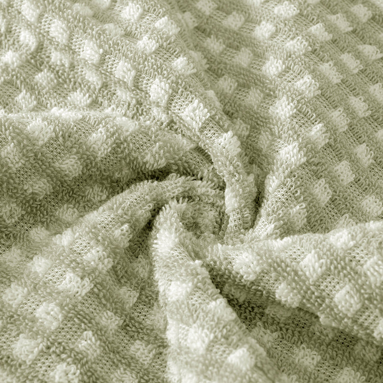 Close-up of textured green fabric with a waffle pattern