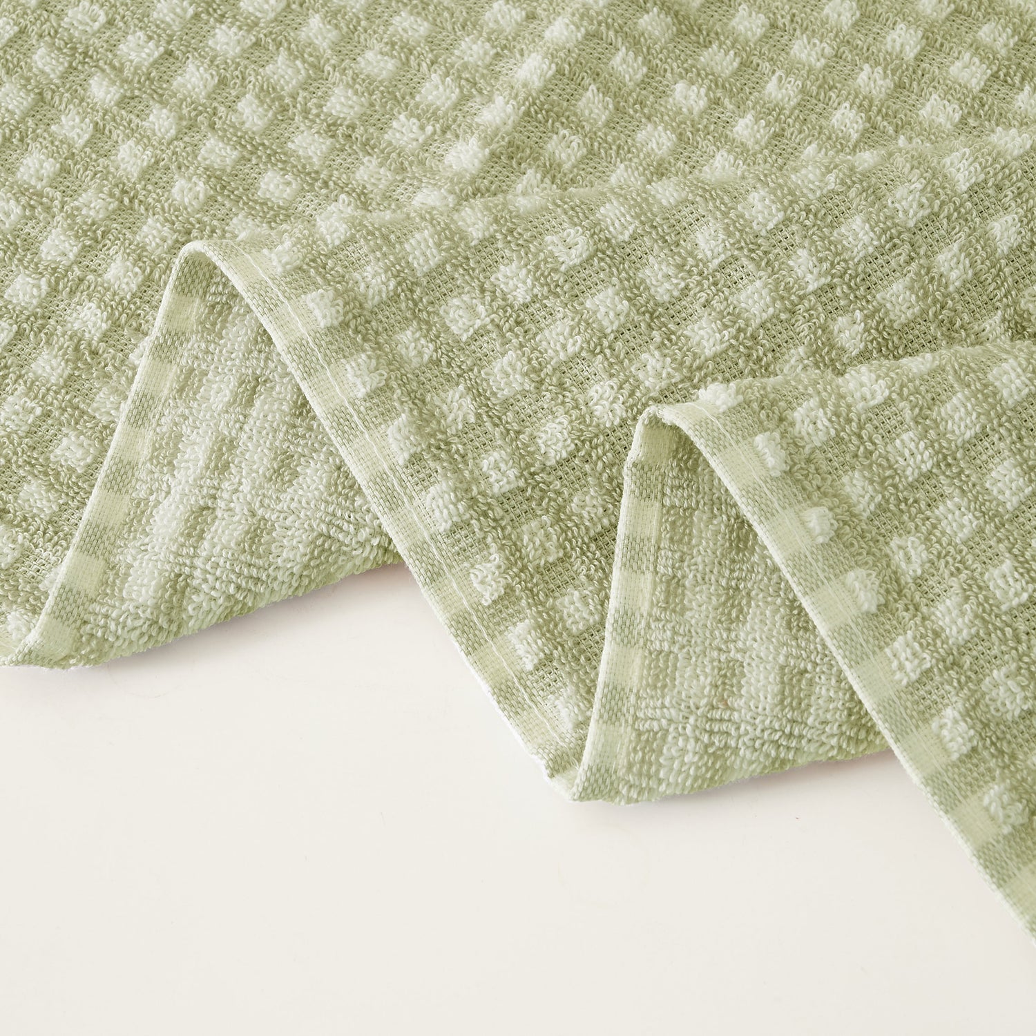 Green textured towel on a white background