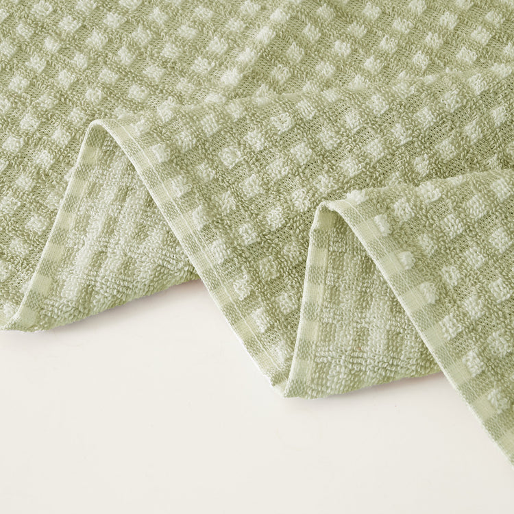Green textured towel on a white background