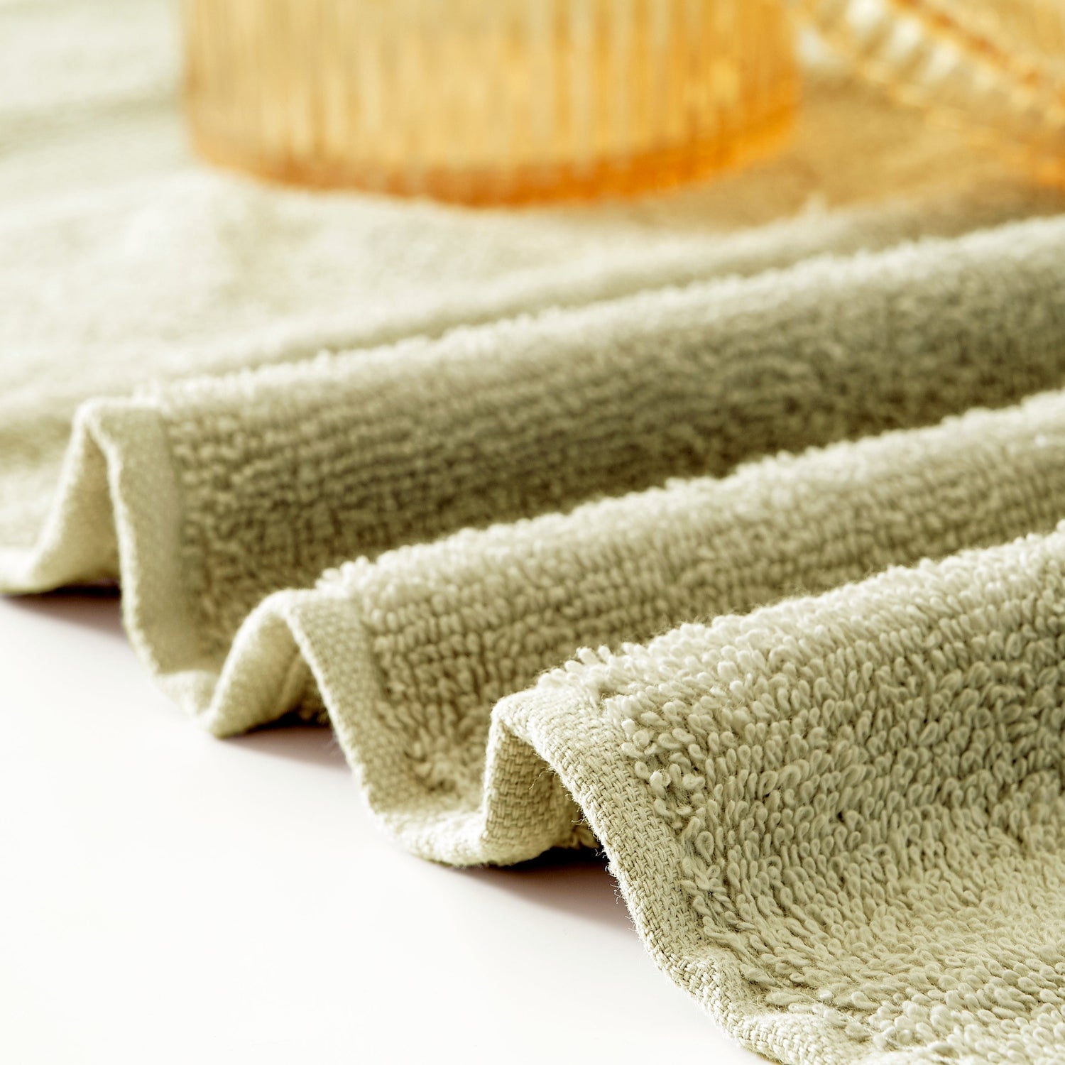 Folded green towel on a light surface