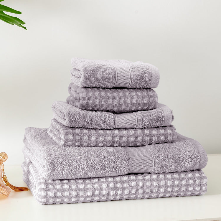 Stack of gray towels on a white surface with a light background
