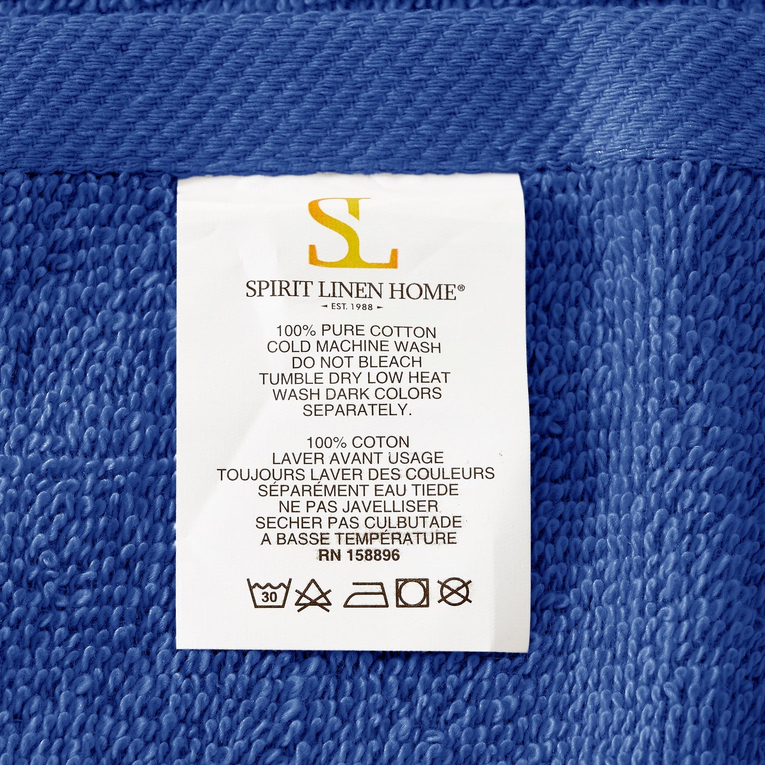 Fabric tag with 'Spirit Linen Home' branding on a blue textured fabric background