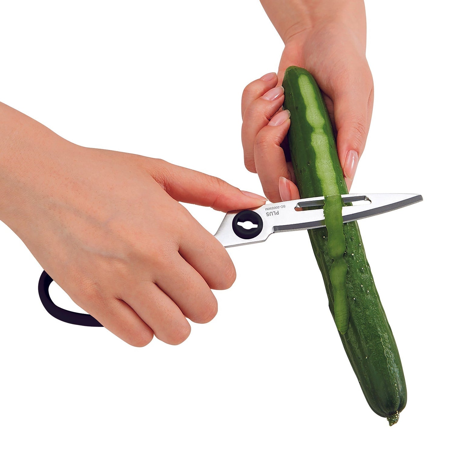 Person using a vegetable peeler to cut a cucumber on a white background