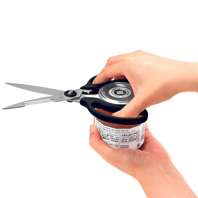 Person using a can opener with scissors on a white background