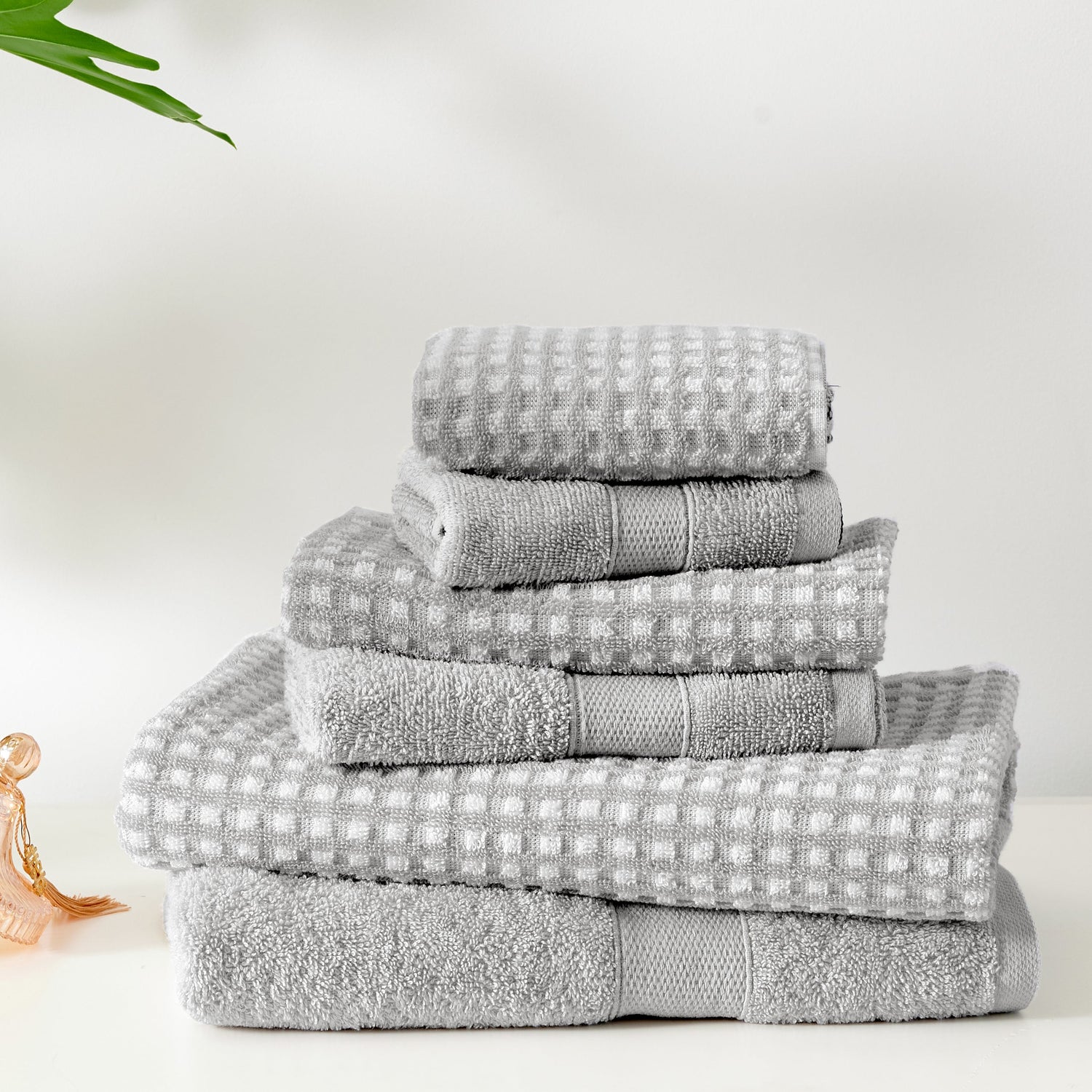 Stack of gray towels on a white surface with a minimal background
