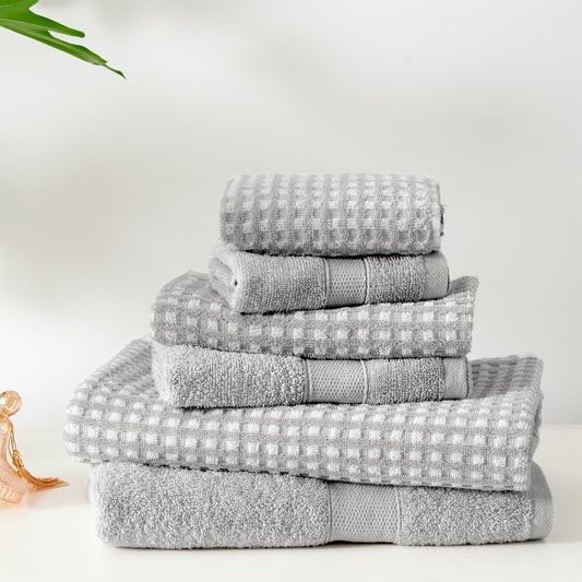 Stack of gray towels on a white surface with a minimal background