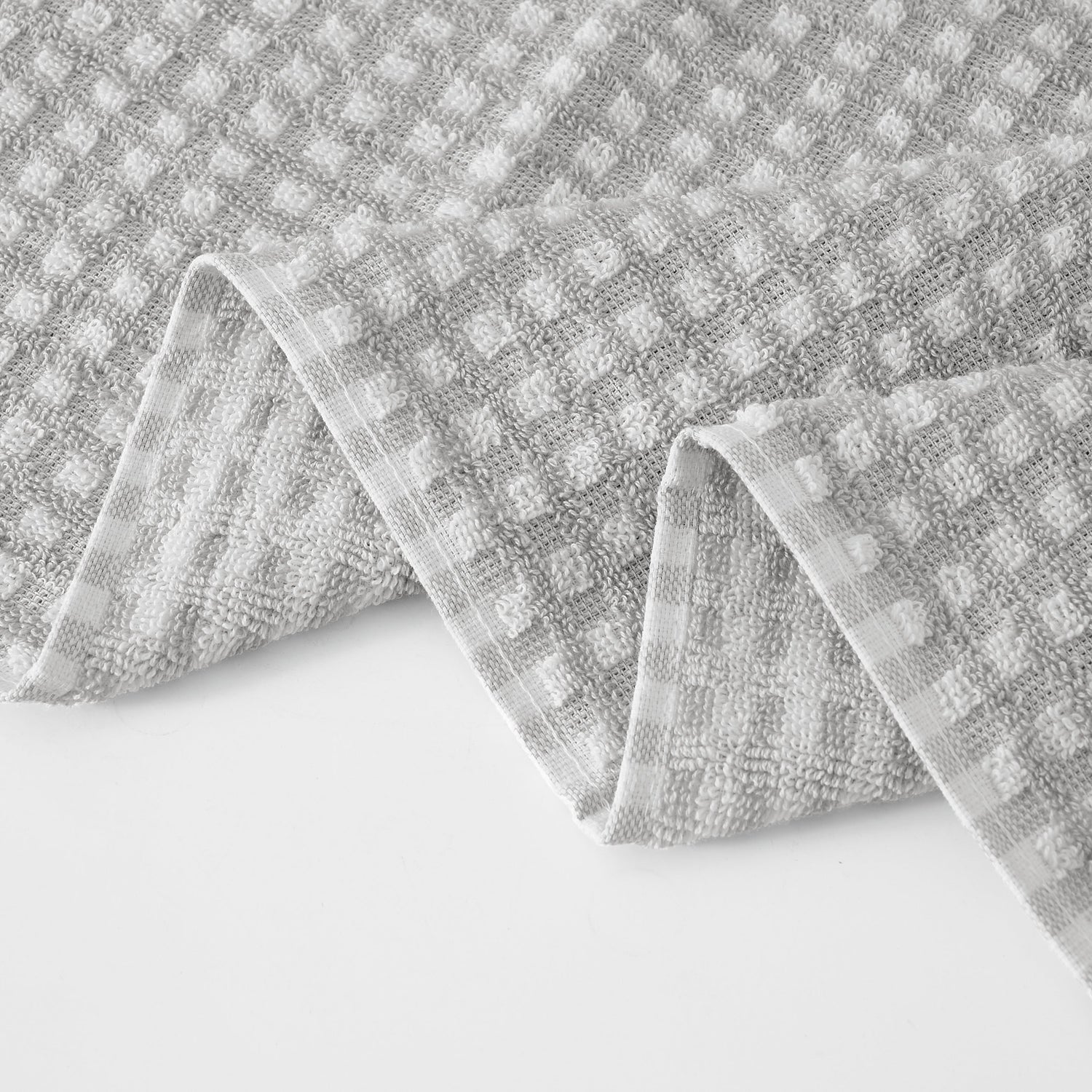 Gray textured fabric with a checkered pattern on a white background