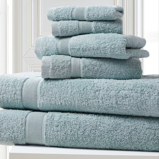 Stack of light blue towels on a white surface with a neutral background